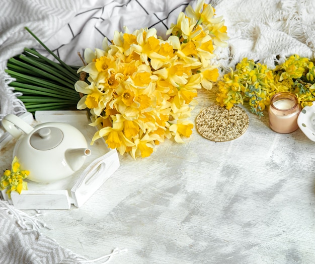 Free photo spring still life with a cup of tea and flowers . light background, blooming and cozy house.