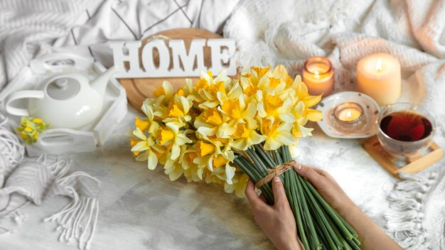 Spring still life with a Cup of tea and flowers . Light background, blooming and cozy house.