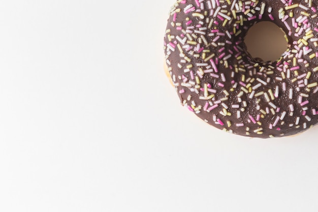 Free photo sprinkles on chocolate donuts over white backdrop