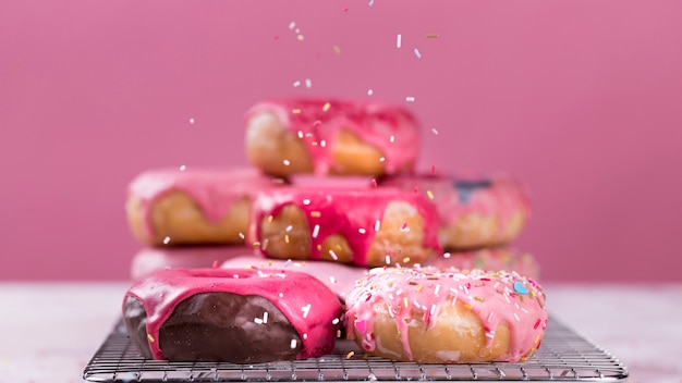 Sprinkles falling on glazed donuts