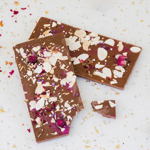 Free photo sprinkles and rose petals on chocolate bar