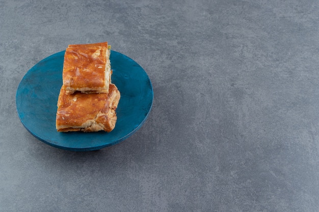 Free Photo square shaped stuffed pastries on blue board.