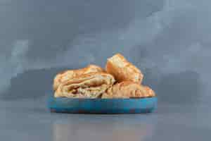 Free photo square shaped stuffed pastries on blue plate.