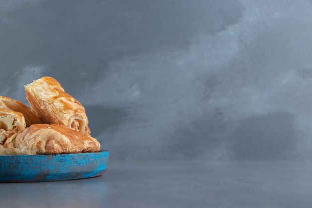 Square shaped stuffed pastries on blue plate.