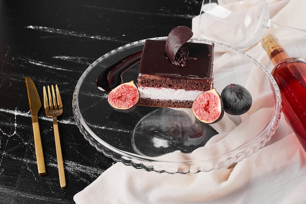 A square slice of chocolate cheesecake on a glass board.