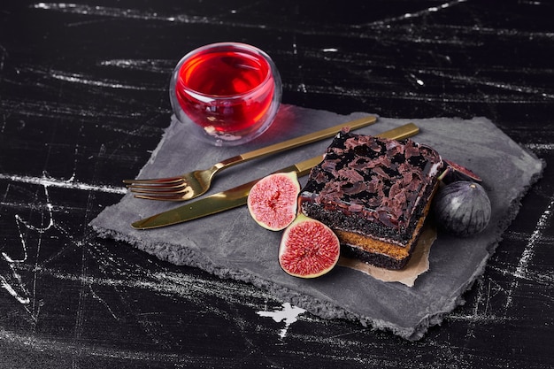 A square slice of chocolate cheesecake with a cup of wine.