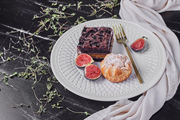 A square slice of chocolate cheesecake with figs and bun.