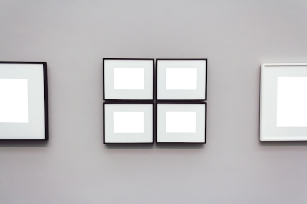 Square white blank frames attached to a gray wall