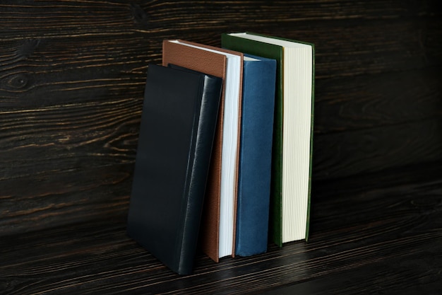 Free photo a stack of books on a dark wooden background