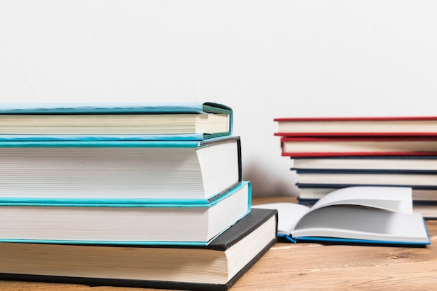 Free Photo stack of books on minimalistic wooden table 