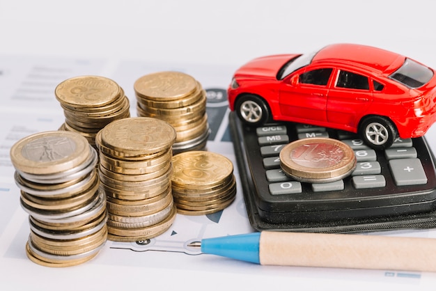 Stack of coins; calculator; toy car and pen on template