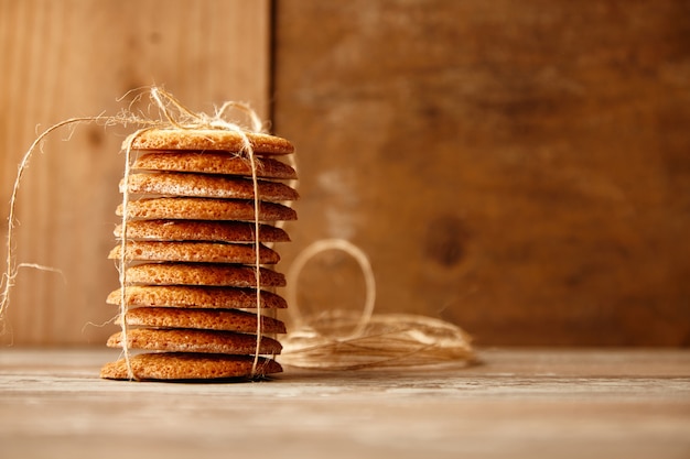 Stack of cookies tied with craft rope on wooden table. Holiday gift idea.