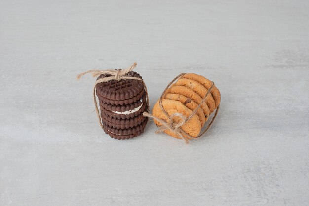 Stack of cookies tied with rope on white table.