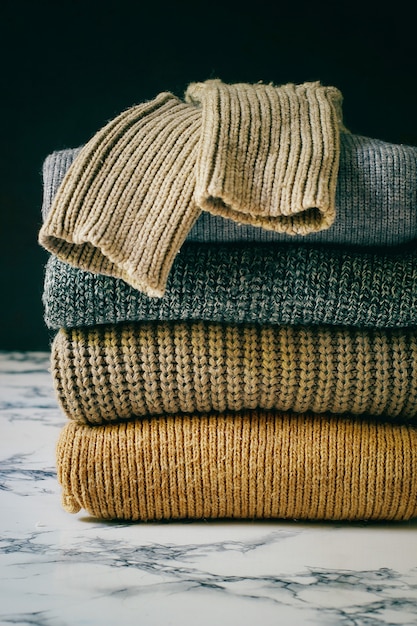 Free photo stack of cozy knitted sweaters. autumn-winter concept, knitted wool sweaters. pile of knitted winter clothes, sweaters, knitwear