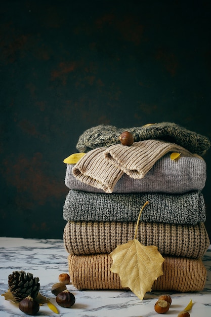 Free photo stack of cozy knitted sweaters. autumn-winter concept, knitted wool sweaters. pile of knitted winter clothes, sweaters, knitwear