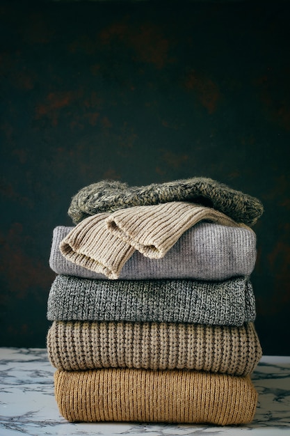 Stack of cozy knitted sweaters. Autumn-winter concept, Knitted wool sweaters. Pile of knitted winter clothes, sweaters, knitwear