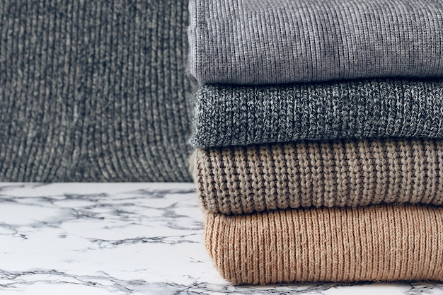 Free photo stack of cozy knitted sweaters. autumn-winter concept, knitted wool sweaters. pile of knitted winter clothes, sweaters, knitwear