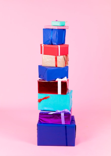 Free Photo stack of different colorful boxes against pink background