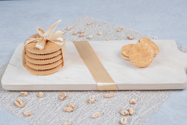 Stack of festive biscuits and peanuts on wooden board. High quality photo