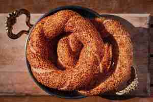 Free photo a stack of freshly baked turkish bagel simit in a copper tray breakfast snacks in turkey top view of fresh baked goods