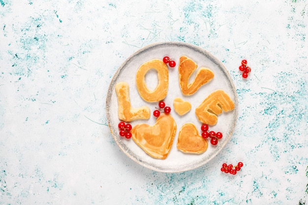 Free photo stack of homemade pancakes with honey syrup and berries.