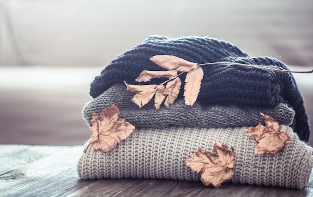 Free photo stack of knitted sweaters on a wooden table