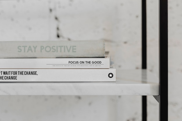 Free Photo stack of psychology books on a white marble shelf