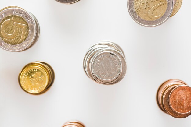 Stack of silver; gold; and copper coins stack on white background