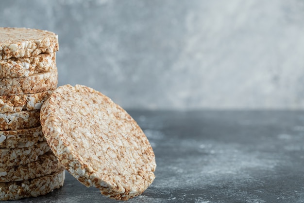 Stack of tasty crispbread on marble surface