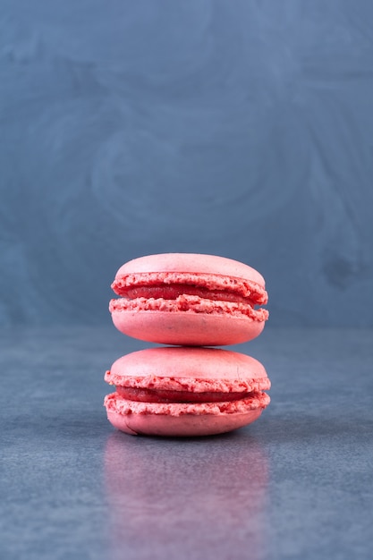 Stack of tasty pink macarons placed on gray surface 