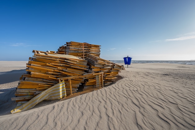 Stack of unused beach chairs on an empty beach