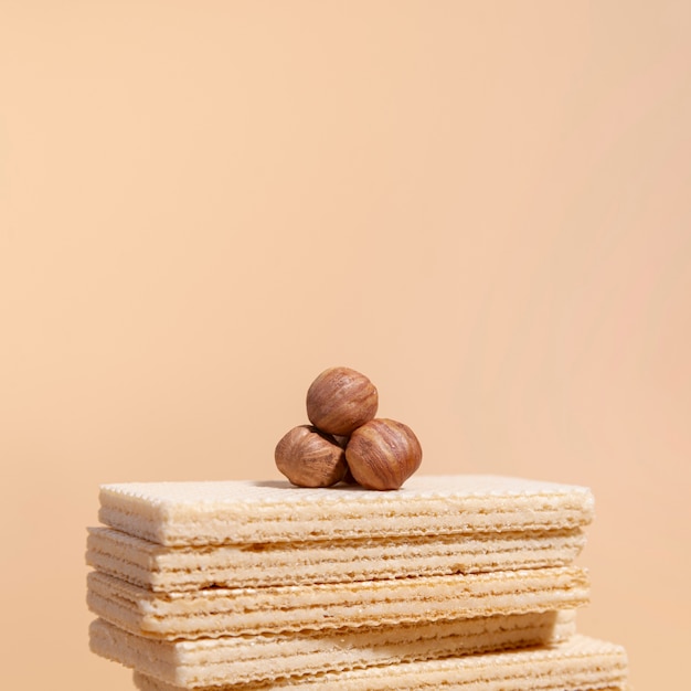 Stack of wafers with hazelnuts on top and copy space