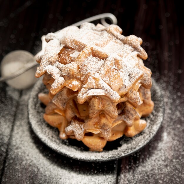 Free Photo stack of waffles on plate with powdered sugar