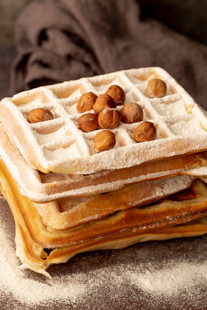 Free Photo stack of waffles with powdered sugar and hazelnuts