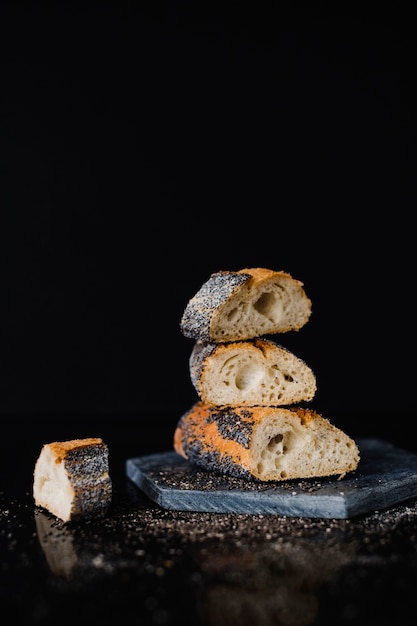 Stacked of bread slice on rock slate against black backdrop