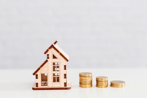 Free photo stacked coins and wooden home