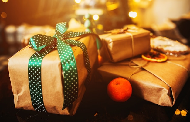 Stacked gifts with green bows and an orange