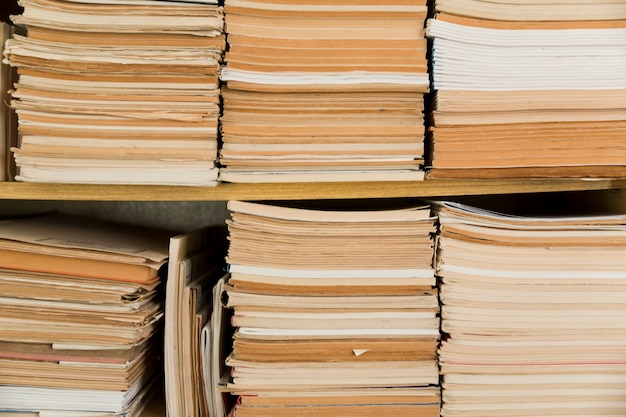 Stacked old notepads on shelf