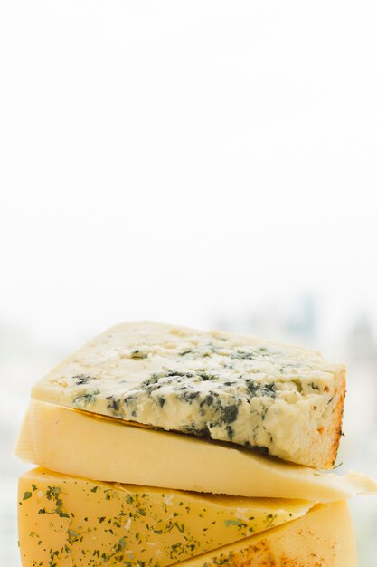 Stacked of triangular cheese slices against white background