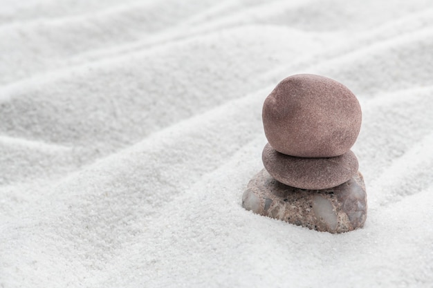 Free photo stacked zen stones sand background in art of balance concept