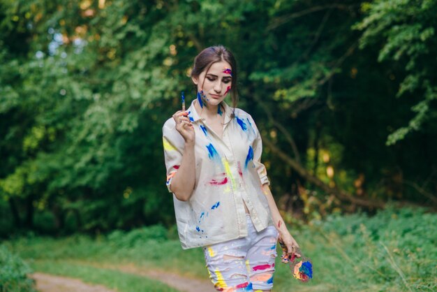 Stained painting woman walking through a field with trees