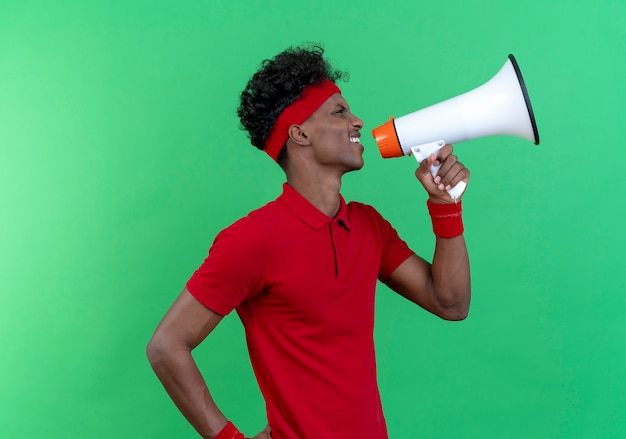 Standing in profile view young sporty man wearing headband