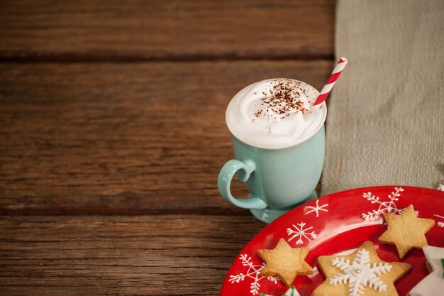 Star shaped cookies on a red plate and cup with cream