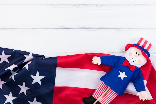 Free photo stars and stripes of american flag and blue-red doll on white surface