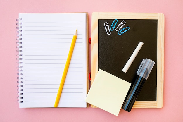 Stationery on notebook and chalkboard