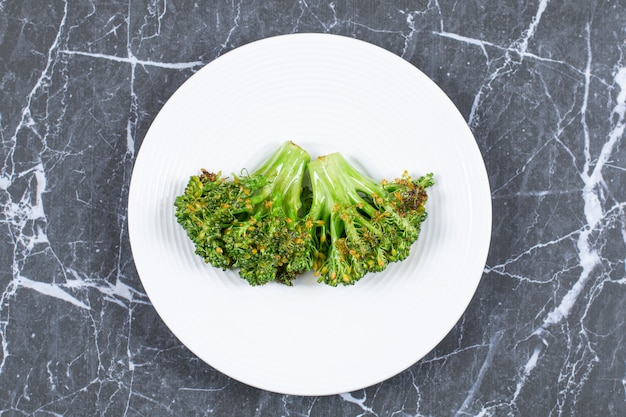 Free photo steamed fresh broccoli on white plate.