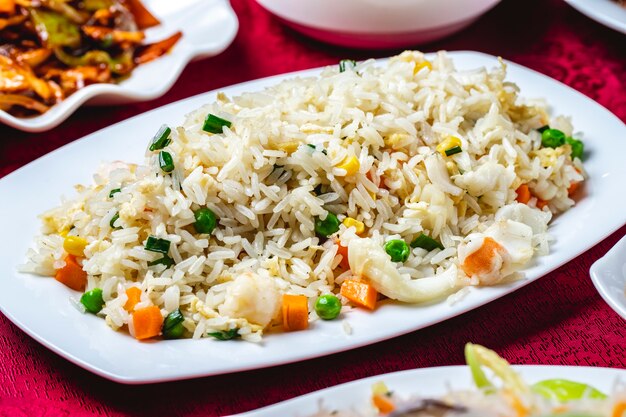 Steamed rice with seafood calamary corns carrot peas side view