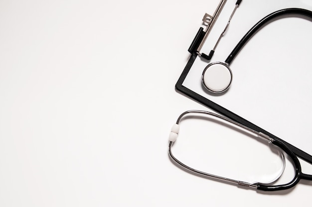 Stethoscope and blank clipboard isolated on white