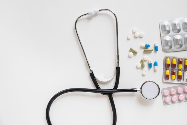 Free photo stethoscope and pills with medicine blister on white background