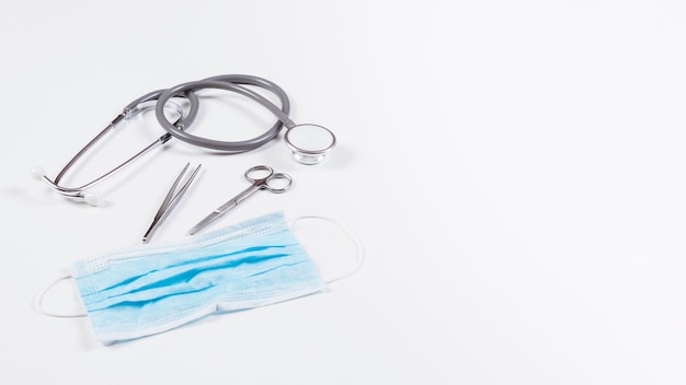 Stethoscope and surgical equipments on white backdrop